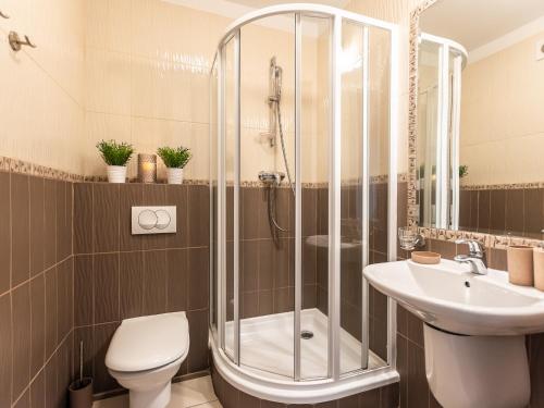 y baño con ducha, aseo y lavamanos. en VacationClub – Avangard Resort Apartament 23 en Świnoujście