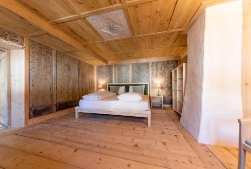 a bedroom with a bed and a wooden ceiling at Wassermann in Sesto