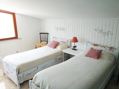 una camera da letto con due letti, un tavolo e una sedia di B&B dei Laghi a Magreglio