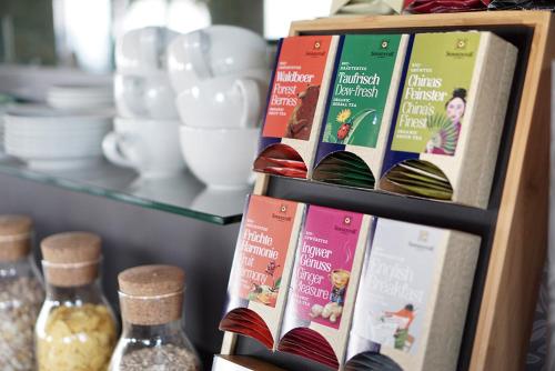 a shelf with books and glass bottles on it at Mahorko Wein Wellness Wasserbüffel in Glanz an der Weinstraße 