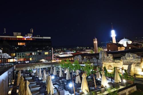 a view of a city at night with umbrellas at Hotel Art in Sarajevo