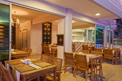 a restaurant with wooden tables and chairs at Sunny Hill Alya Hotel in Alanya