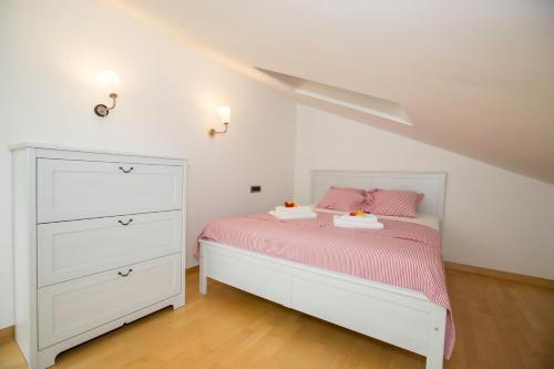 ein Schlafzimmer mit einem weißen Bett und einer weißen Kommode in der Unterkunft Apartment Sanja in Rab