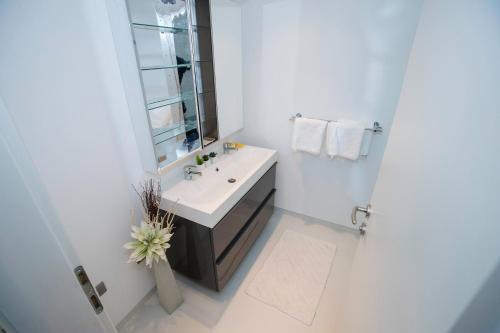 ein weißes Badezimmer mit einem Waschbecken und einem Spiegel in der Unterkunft Apartment Sanja in Rab
