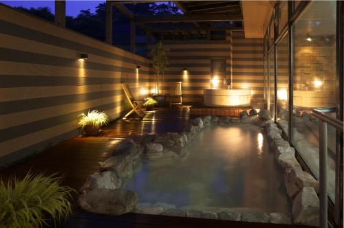 a pool of water with lights on a patio at Hotel Takamatsu in Kusatsu
