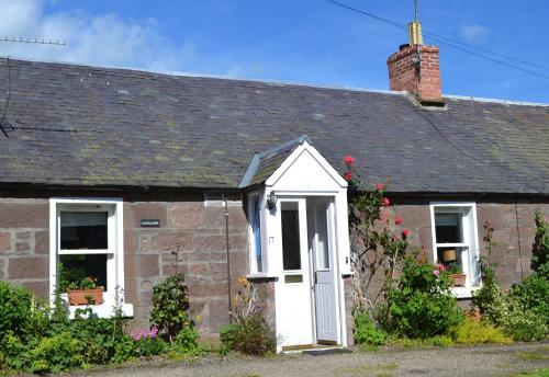 an old brick house with a white door and window at Camlann in Alyth