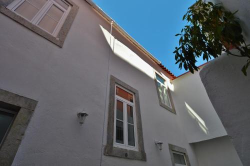 - un bâtiment blanc avec une fenêtre sur le côté dans l'établissement Casa Joana B&B, à Cascais