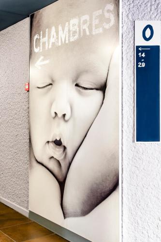 a sign with a baby on the side of a wall at ibis budget Limoges Centre Gare in Limoges