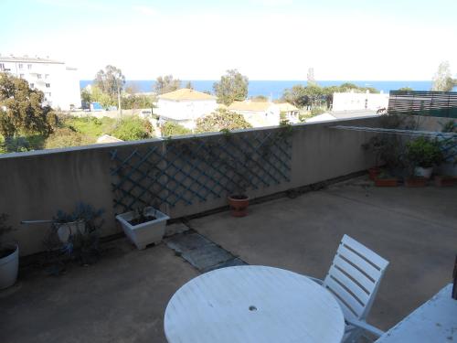 a white table and chairs on a patio with a view of the ocean at L'Arinella in Bastia