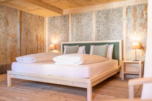 a bedroom with a white bed in a room with wallpaper at Wassermann in Sesto
