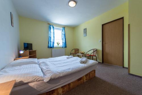 a large bed in a room with a window at Penzion Kosky in Hamr