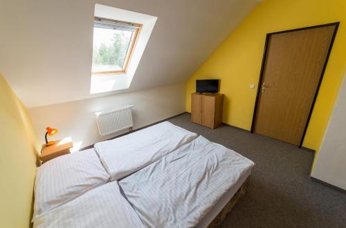 a bedroom with a white bed and a window at Penzion Kosky in Hamr