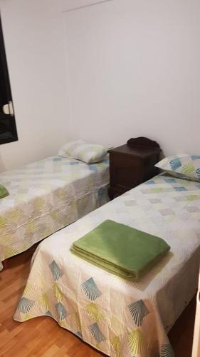 ローマス・デ・サモーラにあるDepartamento Céntrico En Lomas de Zamoraのベッド2台が隣同士に設置された部屋です。