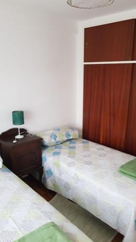 sypialnia z 2 łóżkami i stołem z lampką w obiekcie Departamento Céntrico En Lomas de Zamora w mieście Lomas de Zamora