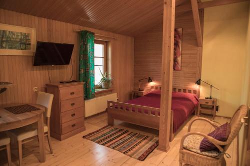 a bedroom with a bed and a table and a desk at Nidos Rojus in Nida