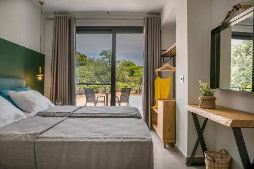 a bedroom with a bed and a balcony with chairs at Villa Lantana in Skala Kefalonias