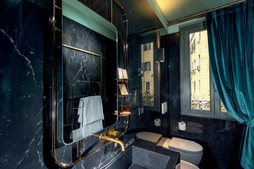 a bathroom with a sink and a toilet and a window at Madama Garden Retreat in Venice