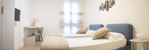 um quarto com uma cama branca e um sofá azul em Casa Felice em Savelletri di Fasano