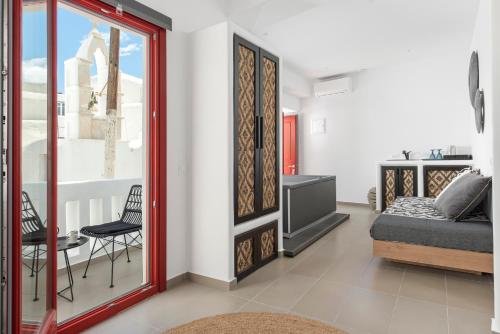 a bedroom with a bed and a living room at Little Venice Villas in Mýkonos City