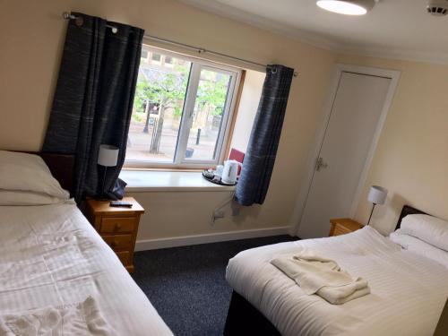 a bedroom with two beds and a window at The Station Hotel in Alness