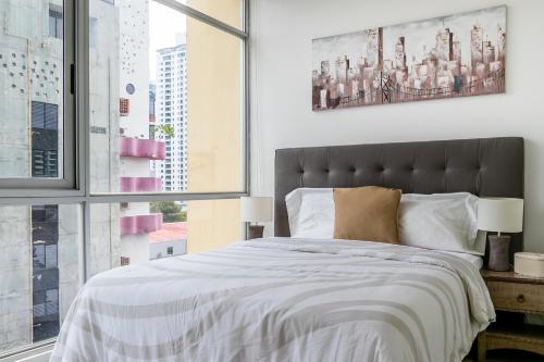a bedroom with a large bed and a window at Breathtaking Apartment City Center - PH Quartier Atlapa in Panama City