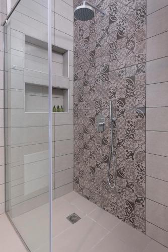 a shower with a glass door in a bathroom at Little Venice Villas in Mýkonos City