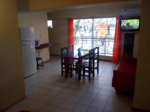 cocina y comedor con mesa y sillas en Alto Godoy Apart en Mendoza