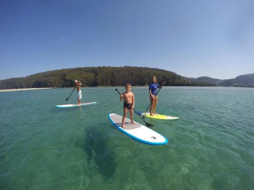 a group of people on paddle boards in the water at Casa en primera linea de playa en Pantin!! in Pantín