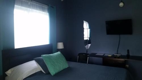 a bedroom with a bed and a desk and a window at Bailey's Bed and Breakfast in Runaway Bay