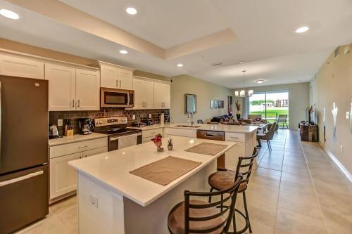 a large kitchen with white cabinets and a large island at H - New 2 Bedroom Condo - 5 Miles to Disney - Free Water Park in Kissimmee