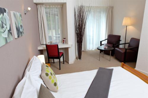 a hotel room with a bed and a living room at Hôtel Restaurant Le Saint-Christophe in Bex