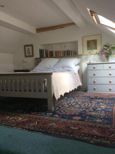 a bedroom with a bed with a dresser and a drawer at Arch Cottage in Chagford