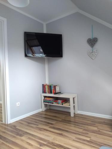 a living room with a flat screen tv on a wall at Apartament Nad Jeziorem Kaszuby in Gołubie
