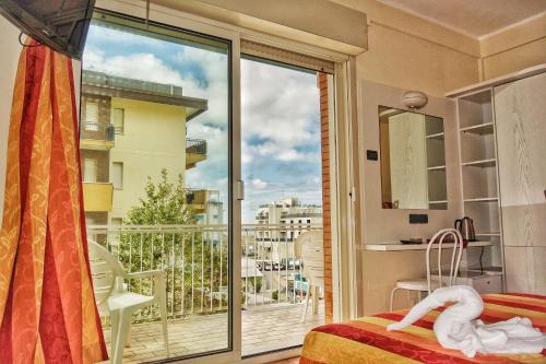 a bedroom with a view of a balcony at Hotel Tridentum in Cesenatico