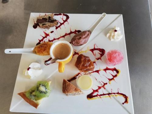 a white plate with food and a cup of coffee at le relais des forêts in Blessac