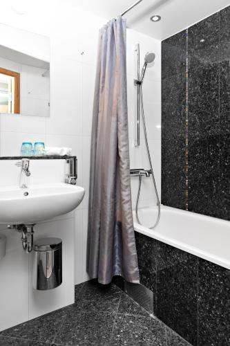 a bathroom with a shower curtain and a sink at Best Western Hotel Arena in Gothenburg