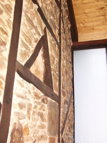 a stone wall next to a window in a building at Alojamiento Luz de Hadas in Sampil