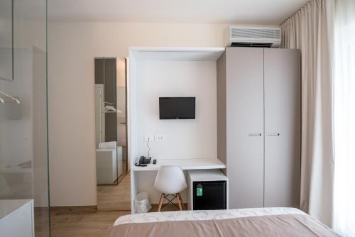 a bedroom with a bed and a desk and a tv at Hotel Relax Family & Spa in San Benedetto del Tronto