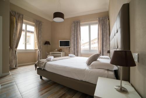 1 dormitorio con 1 cama grande y 2 ventanas en D'HOME FLORENCE en Florence