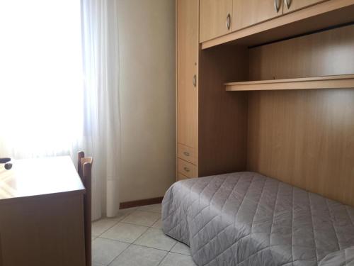 a small bedroom with a bed and a cupboard at APPARTAMENTO DALMAZIA 10 in Lido di Jesolo