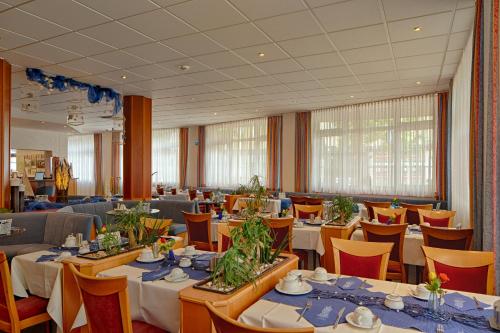un comedor con mesas y sillas en una habitación en RIESENjunior Hanau by Trip Inn, en Hanau am Main