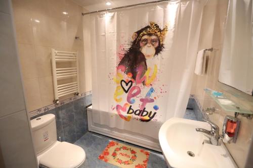 a bathroom with a shower curtain with a monkey on it at Avenue Hostel Yerevan in Yerevan