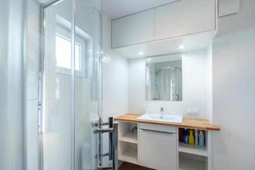 a bathroom with a sink and a mirror at Lubiatowe Love - domki w otulinie lasu in Lubiatowo