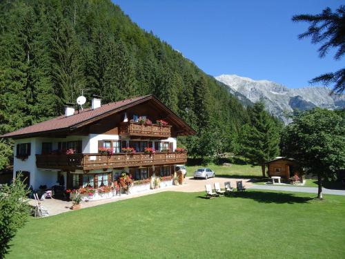 a large building with a balcony and a mountain at Landhaus Manuela & Haus Michael in Leutasch