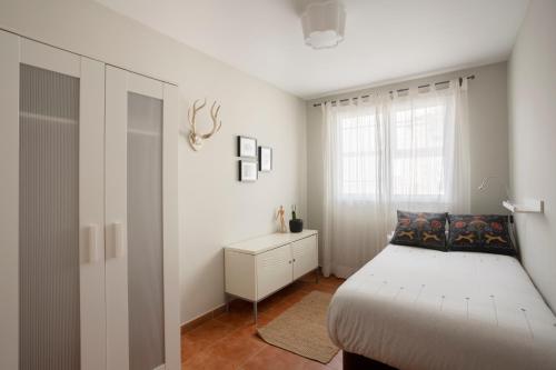 a white bedroom with a bed and a window at Apartamento Bed&Center 2A in Lugo