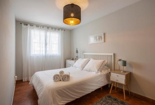 una camera da letto con un letto bianco con due asciugamani di Apartamento Bed&Center 2A a Lugo