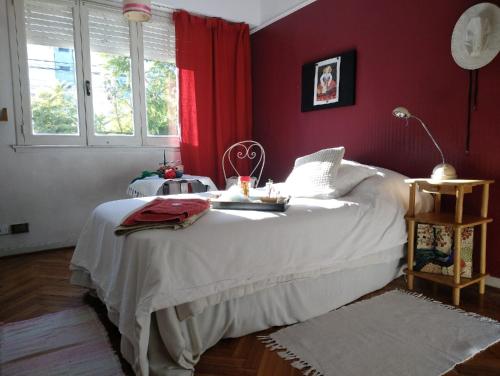 una camera con un letto bianco e pareti rosse di Dormitorios La Lucila Vicente Lopez Sol & Tren a La Lucila