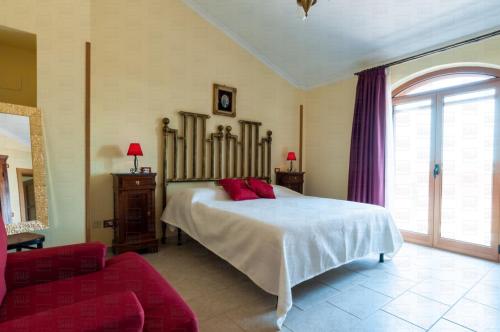 sypialnia z łóżkiem i czerwoną kanapą w obiekcie HelloApulia - Villa Flora w mieście Noci