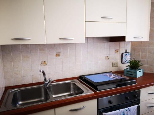 una cocina con fregadero y estufa en Stella Maris, en Favignana