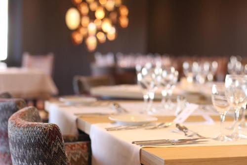 a set of tables with wine glasses on them at Evora Hotel in Évora